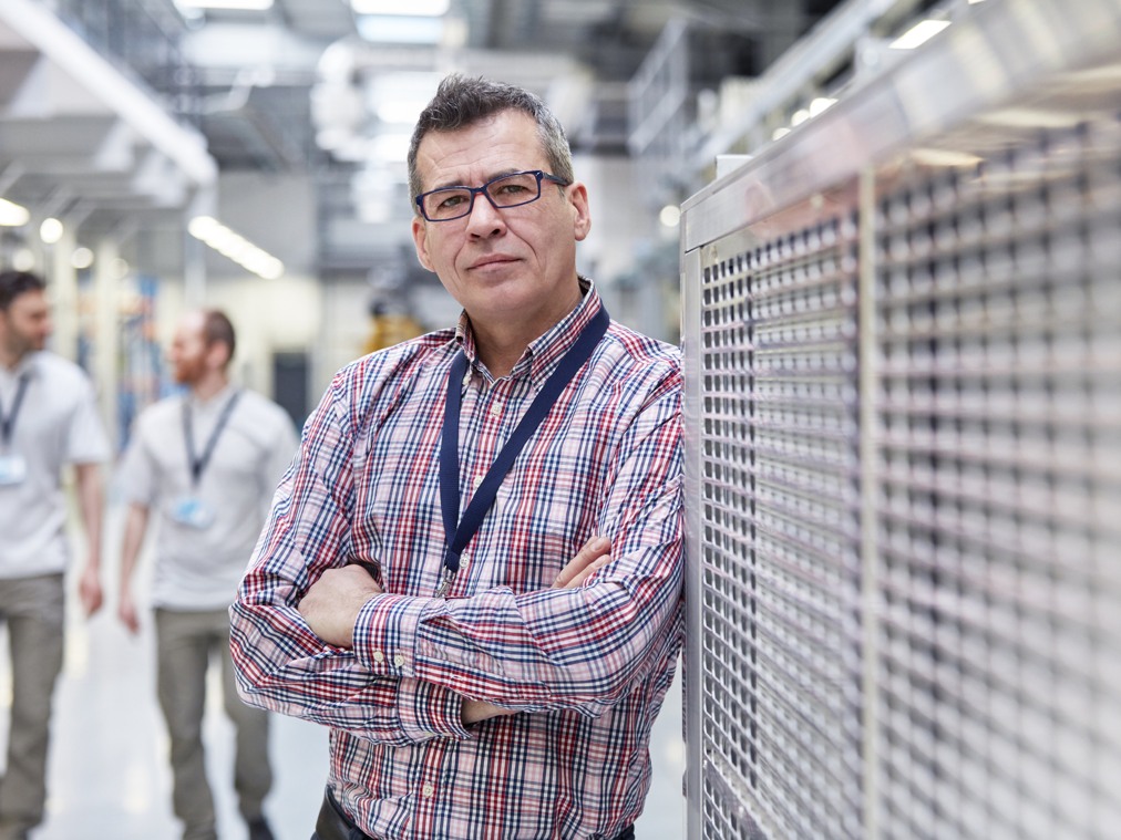 Några män i vanliga kläder i en fabrik.