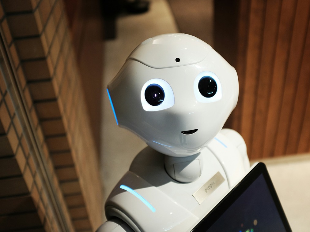 Söt, vit robot med lysande ögon.