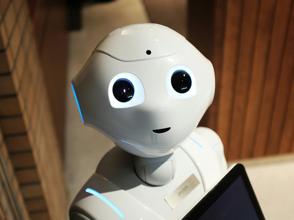 Söt, vit robot med lysande ögon.