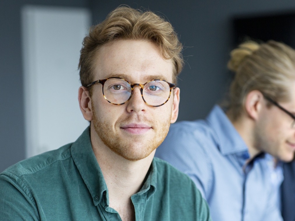 En grupp människor som sitter vid ett bord med bärbara datorer.