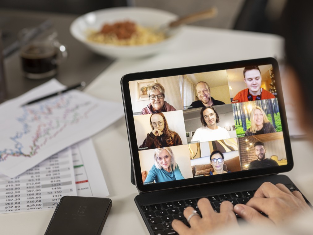 En  bärbar dator med en grupp människor på skärmen i digitalt möte.