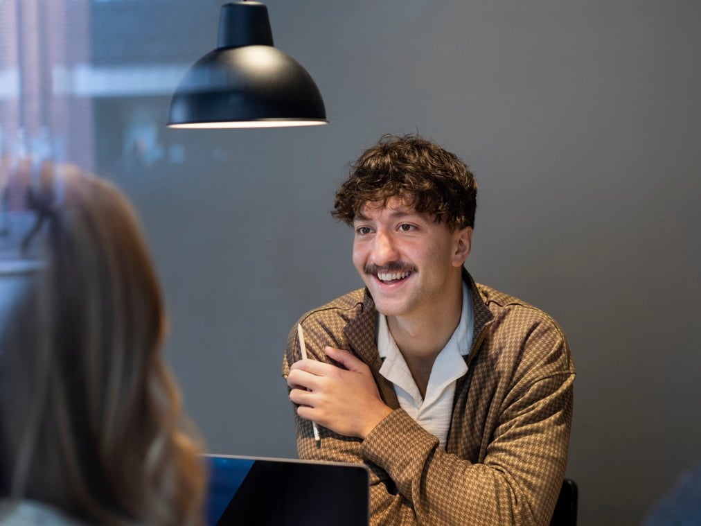 En man sitter framför en bärbar dator.