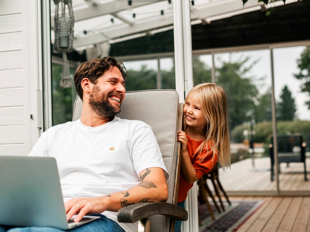 A man sitting in a chair next to a little girl.