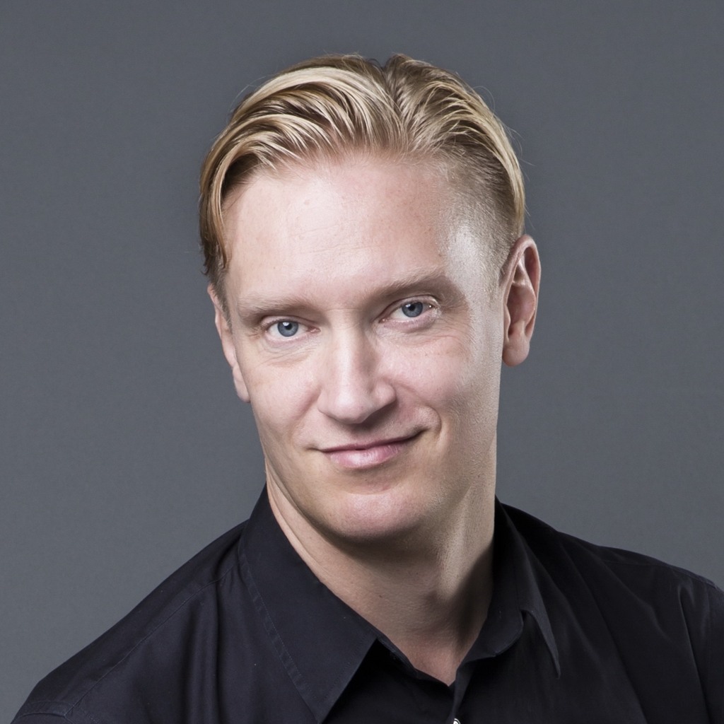 En man med blont hår som bär en svart skjorta.
