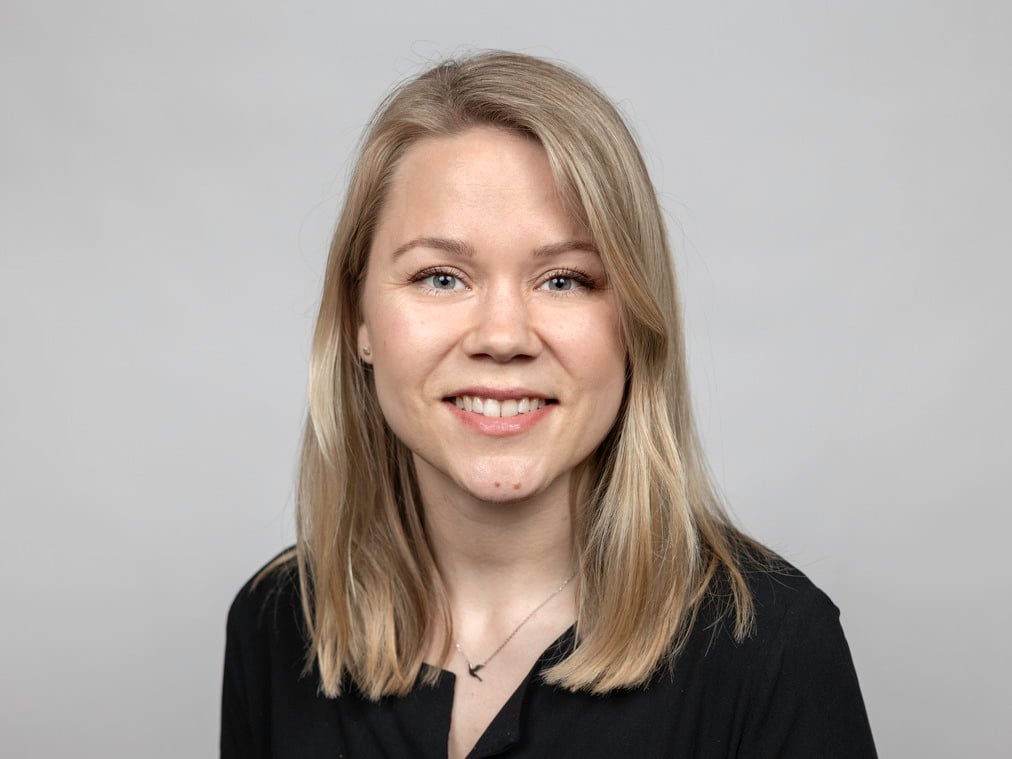 En kvinna i svart skjorta som ler mot kameran.