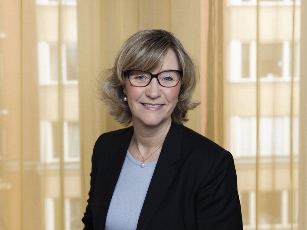 En kvinna med glasögon och svart kavaj.