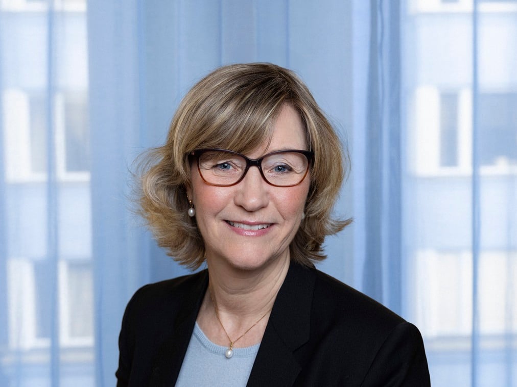 Camilla Frankelius, wearing glasses and a black blazer.